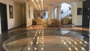 A spacious lobby with a polished floor, a staircase, and several seating areas. - Public Security Hotel & Chalets (Aqaba)