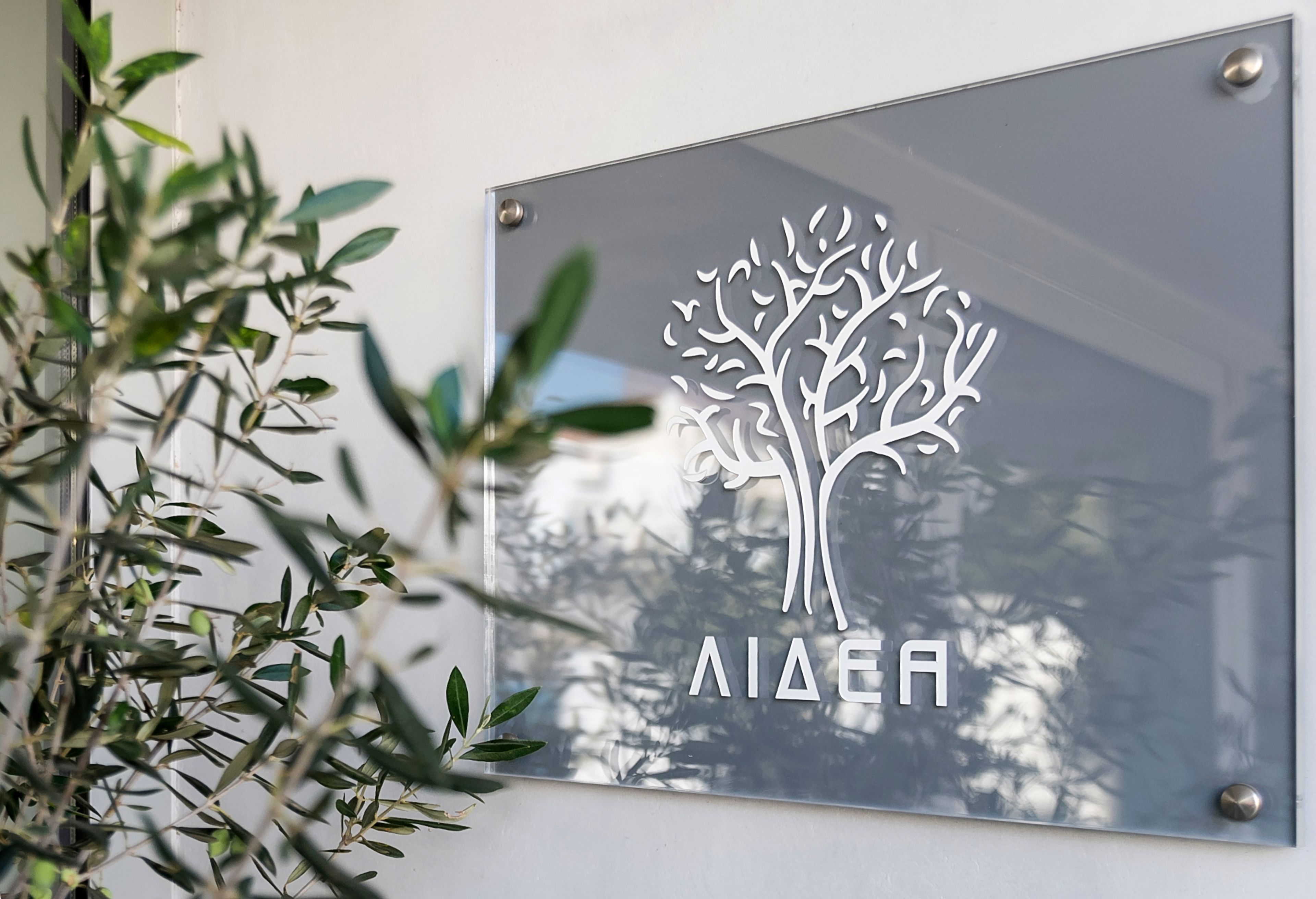 Eine Glasplakette mit einem Baumdesign und der Aufschrift 'AIAEA'.