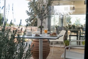 Ein Essbereich im Freien mit Tisch, Stühlen und einem großen Terrakotta-Topf.