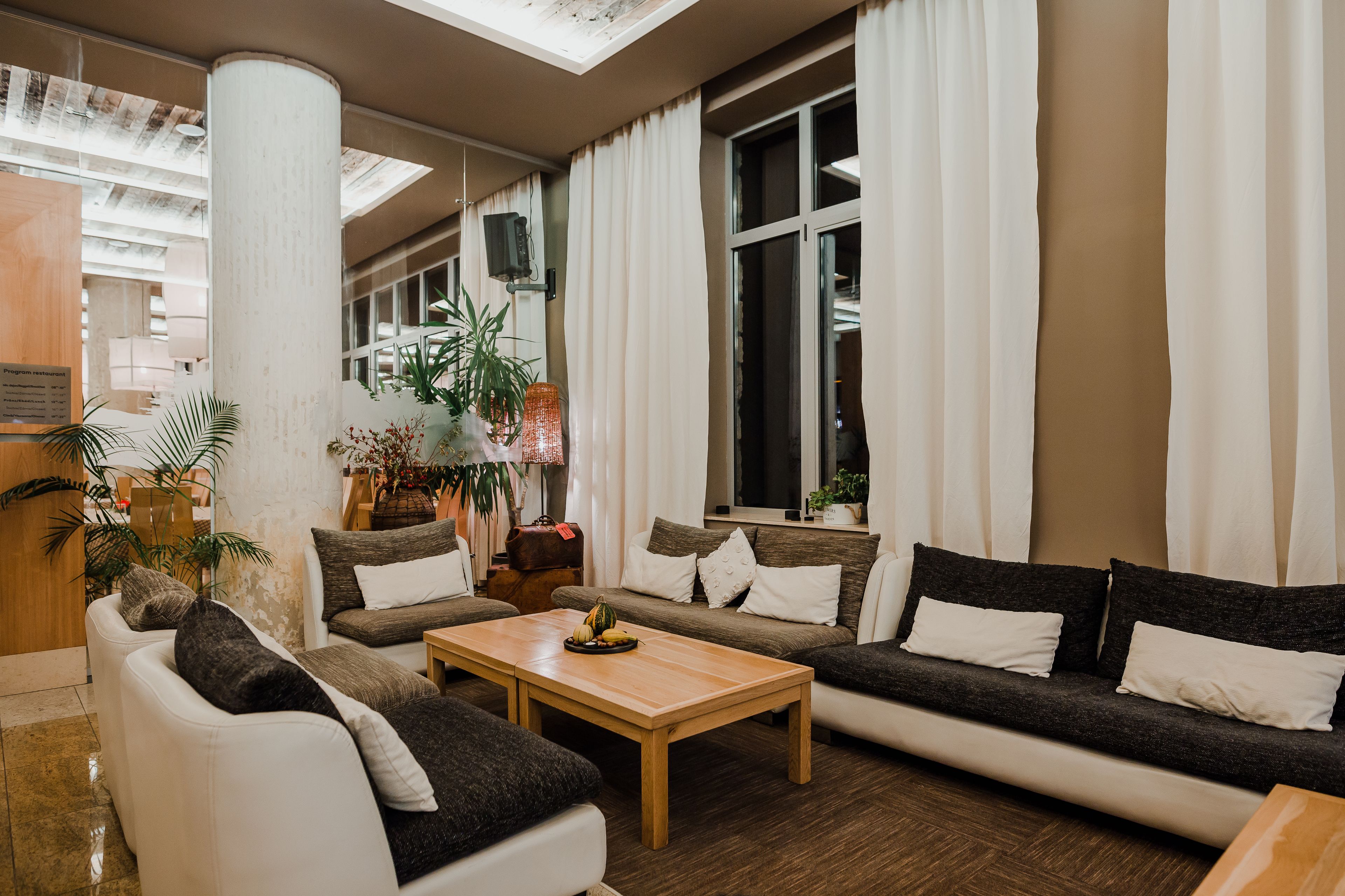 Una sala de estar moderna con un sofá, una mesa de centro y un ventanal con cortinas.