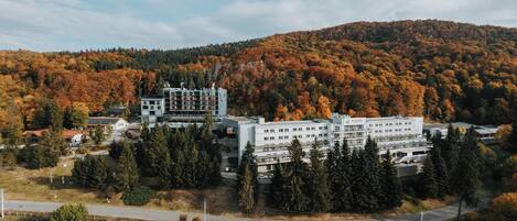 A large building complex surrounded by autumn foliage.