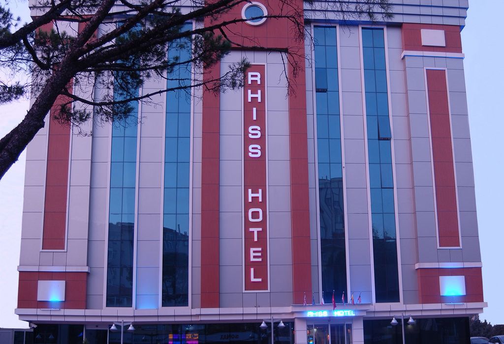 The exterior of the RHISS HOTEL with a prominent vertical sign displaying its name.