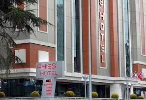 A modern hotel with a sign reading "RHISS HOTEL" and a list of amenities including restaurant, fitness, hammam, and sauna. - Rhiss Hotel Bostanci (Istanbul)