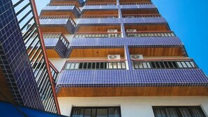 A multi-story building with a modern design, featuring balconies and large windows. - Hotel Brisa Rio (Jacarei)