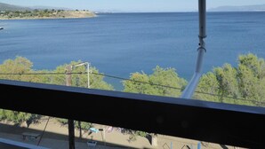 A view from a balcony overlooking a large body of water, with a distant shoreline and some vegetation. - Hotel Poseidon (Chalcis)