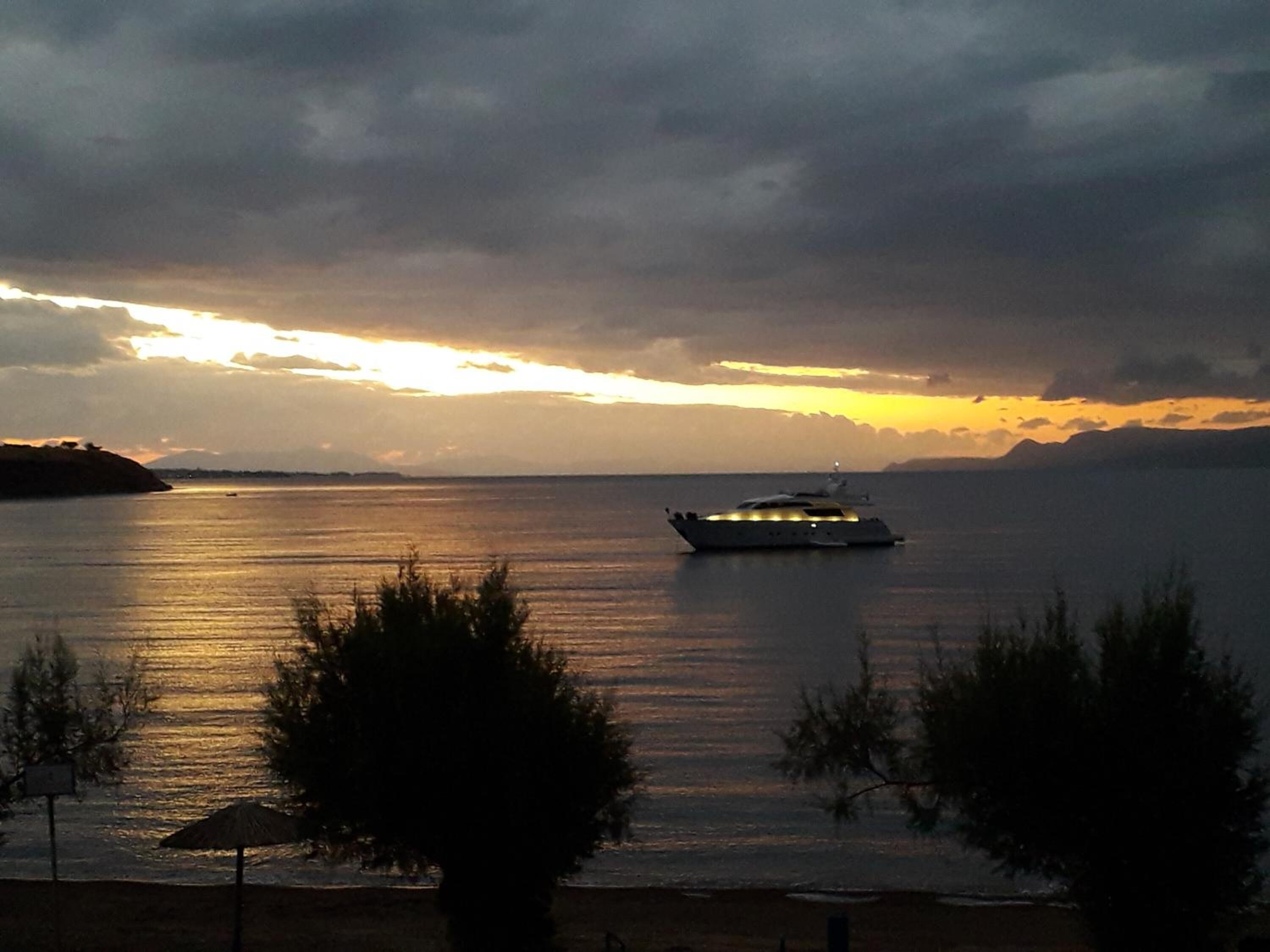 A boat on a calm sea during sunset.