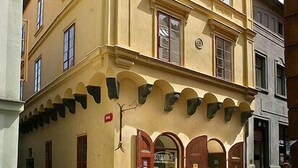 Un edificio de varios pisos con fachada amarilla, ventanas grandes y una entrada destacada con puerta roja.