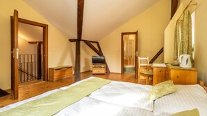 Un dormitorio con una cama grande, muebles de madera, una escalera y vistas al exterior.