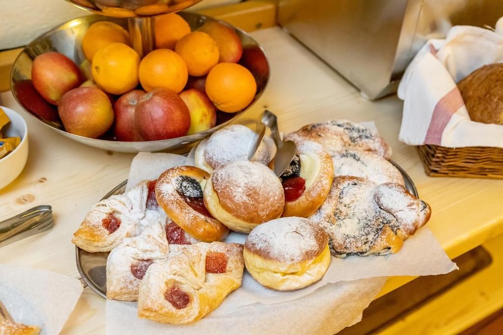 Una mesa con pasteles y un bol de fruta.