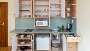 Una cocina funcional con microondas, lavamanos y varios armarios de almacenaje.