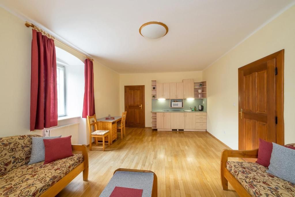 Een knus woongedeelte met een bank, een eettafel en een kitchenette.