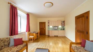 Een knus woongedeelte met een bank, een eettafel en een kitchenette.