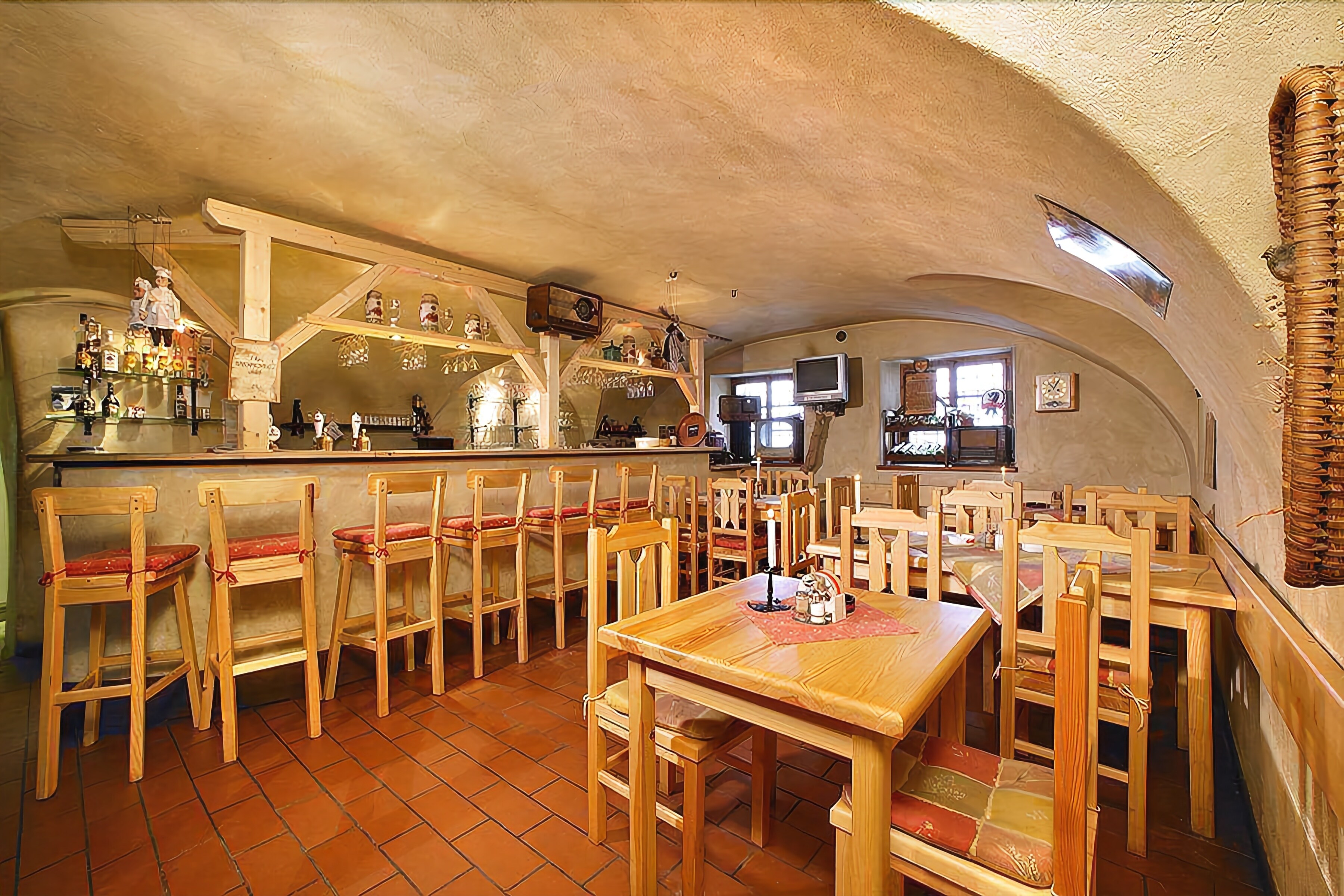 Ein rustikales Restaurant mit Holzkubaturen, einer Bar und einem Fernseher.