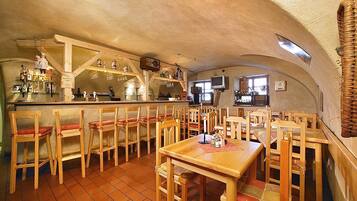 Ein rustikales Restaurant mit Holzkubaturen, einer Bar und einem Fernseher.