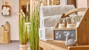 A wooden shelf with glass jars, a chalkboard with writing, and a white towel. - DAS LUDWIG Sports Resort (Bad Griesbach im Rottal)