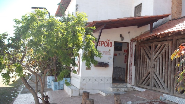 A building with a tiled roof and a sign reading "EPÇAO". - Pousada Chalé Suiço (Parnaíba)