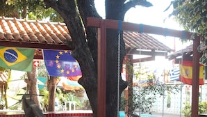 A playground with swings and a seesaw. - Pousada Chalé Suiço (Parnaíba)
