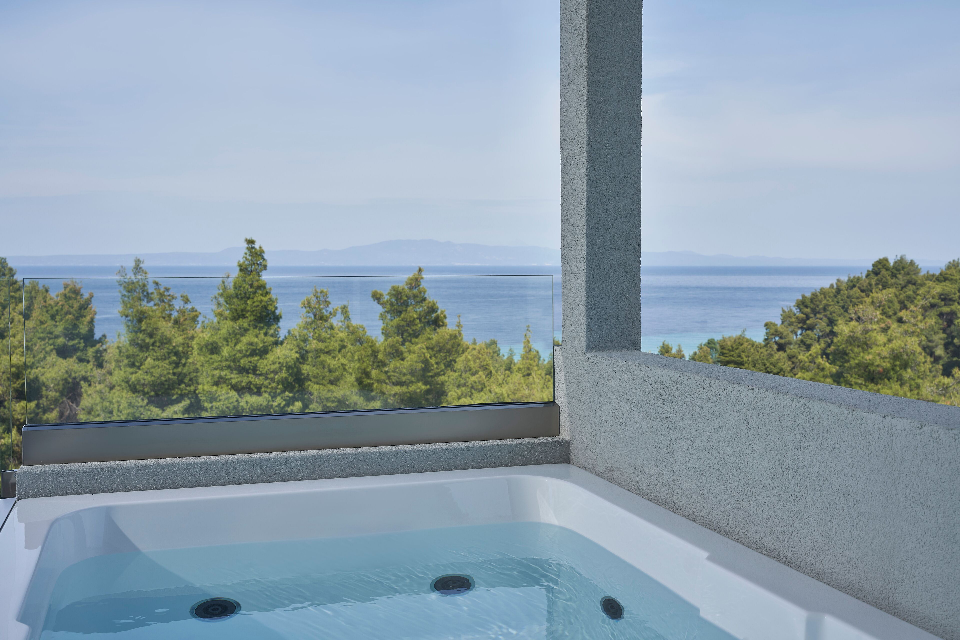 Ein Whirlpool mit freiem Blick auf das Meer und Bäume.