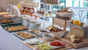 Un bufé de desayuno con diversas opciones de comida y un cartel que dice 'HOME'.