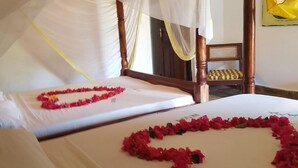 A hotel room with two beds, each adorned with a heart-shaped arrangement of red flowers. - Kenga Giama Resort (Malindi)