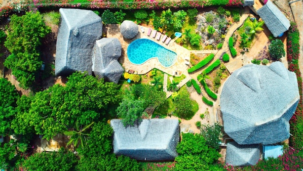 An aerial view of a resort with a swimming pool, large rock formations, and lush greenery. - Kenga Giama Resort (Malindi)