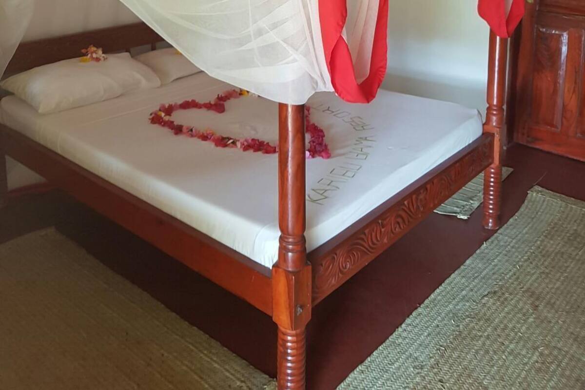 Un lit à baldaquin avec une tête de lit en bois.