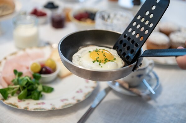 A breakfast setting with a frying pan, a plate with food, and a cup. - Les Gomines BB (Marebbe)