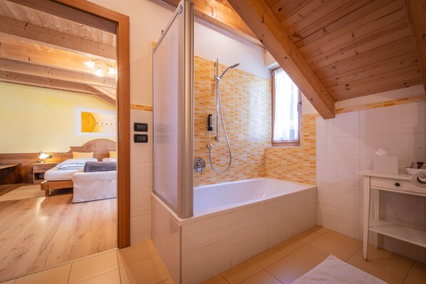 Un baño moderno con una bañera independiente, ducha y techo de madera.