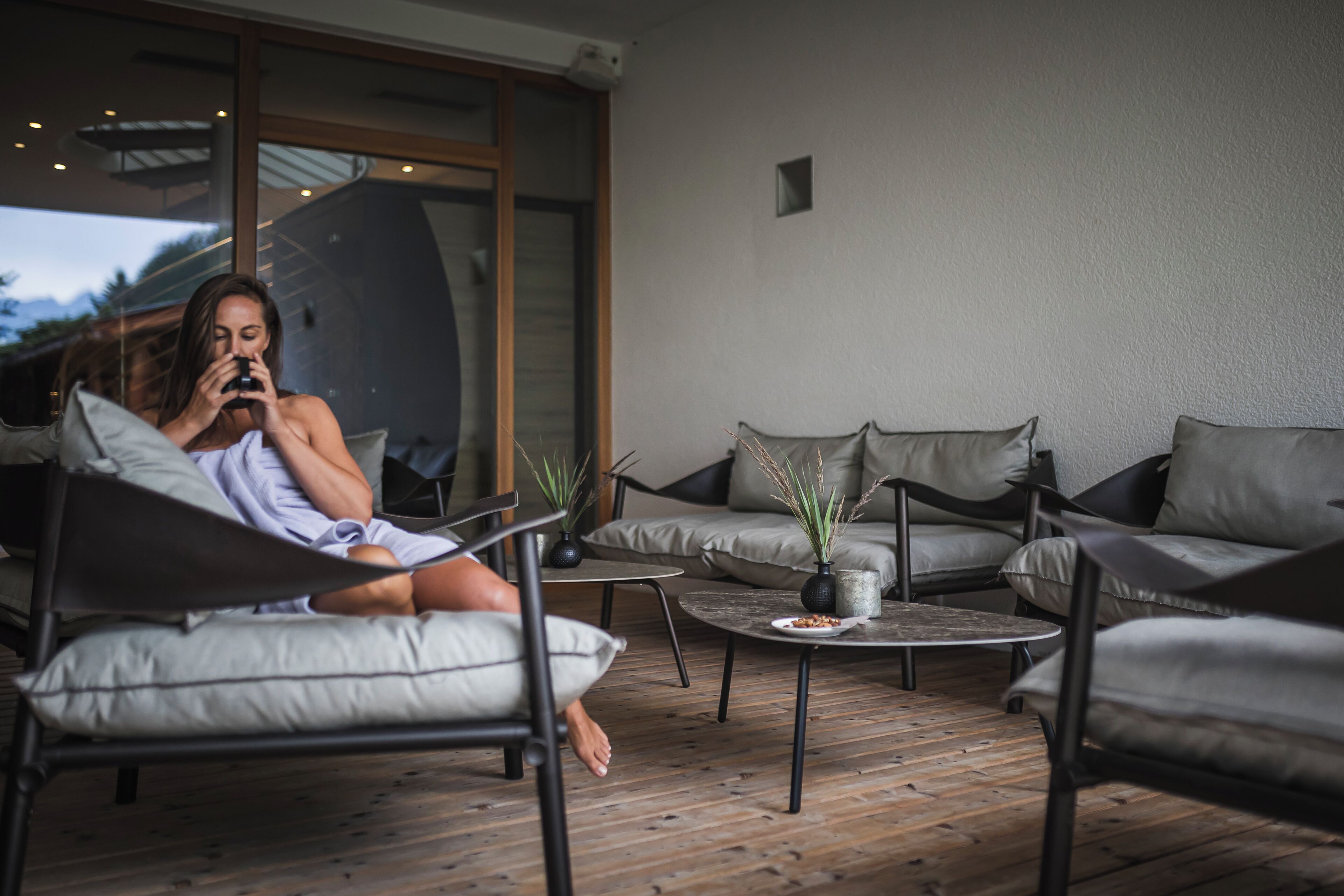 Ein stilvoller Außenbereich mit einer Couch, Sesseln und einem Couchtisch.