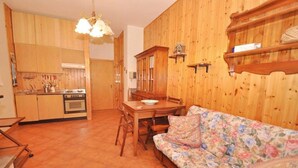 A wooden interior with a dining area, a sofa, and a kitchen. - Amami Viaggi - Casa del Sannio (Roccaraso)