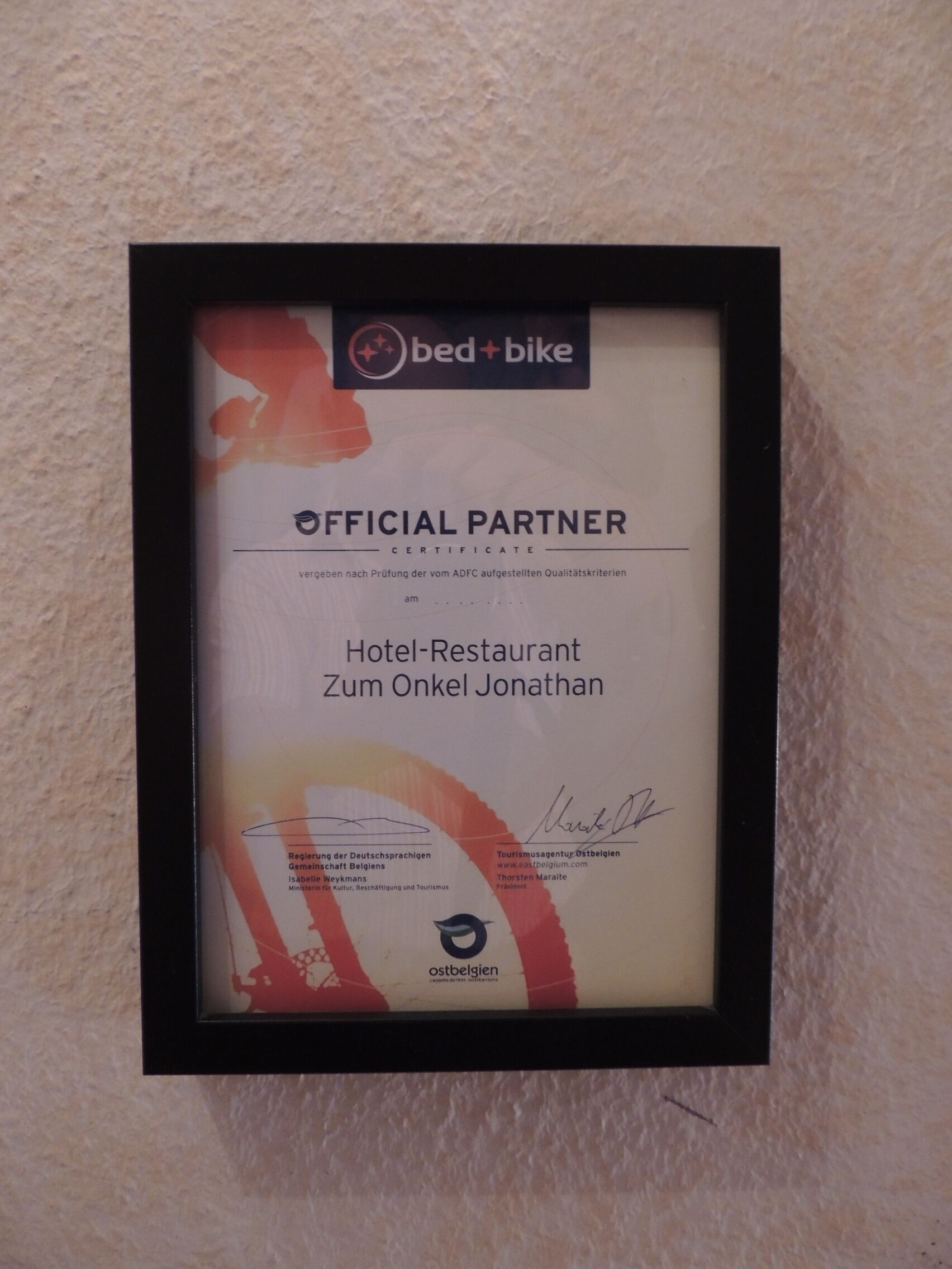 A framed certificate for an official partner of a hotel and restaurant named Zum Onkel Jonathan.