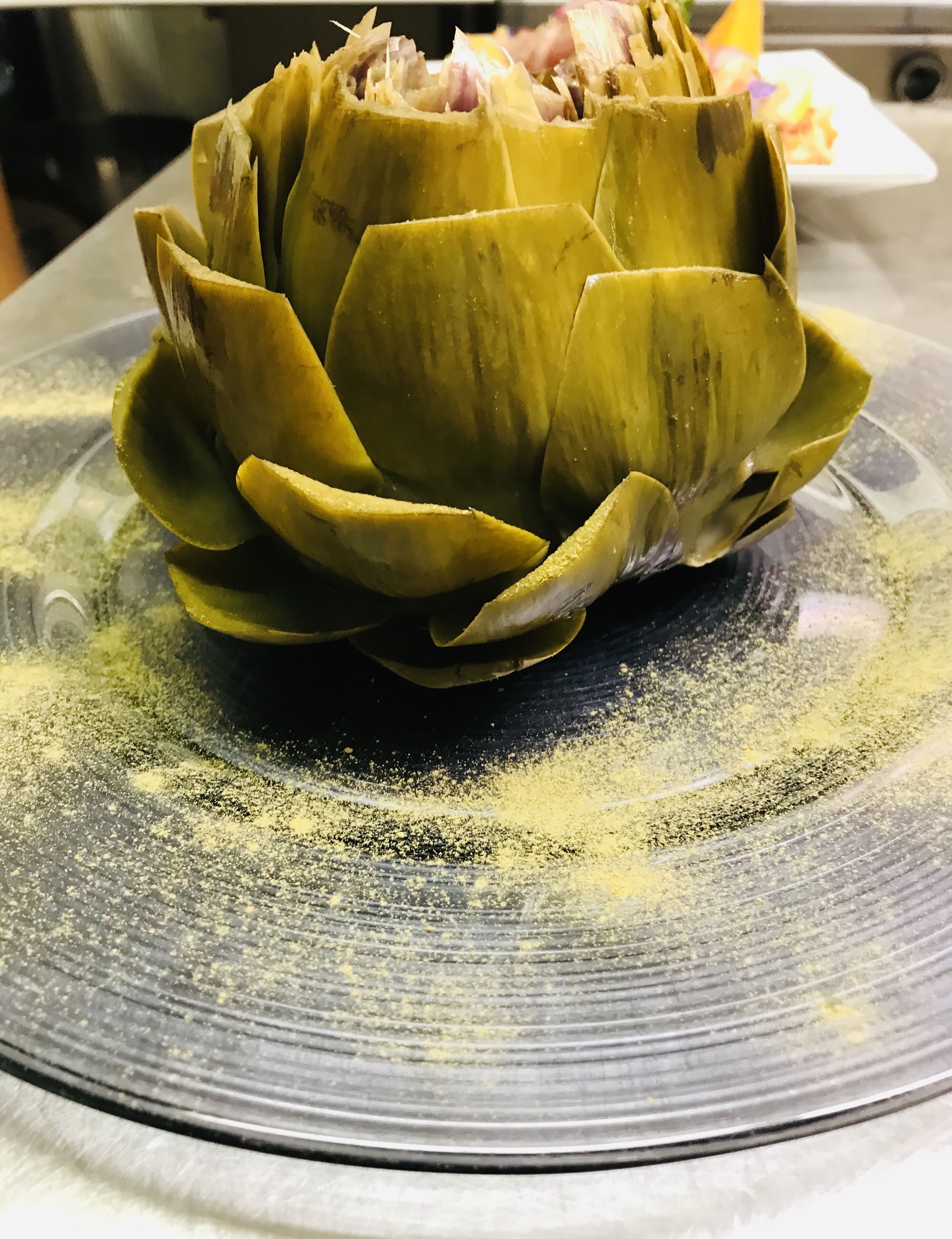 Un alcachofa en un plato con superficie texturizada.