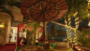 A carousel with a canopy, surrounded by colorful tires and tropical plants. - Hostal Gosén (Puerto Baquerizo Moreno)