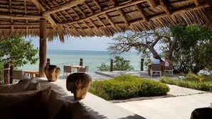A thatched-roof outdoor seating area with a view of the sea. - Jua Retreat (Michamvi)