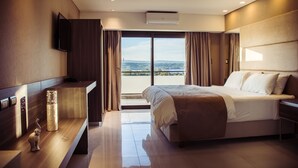 Una habitación de hotel moderna con una cama grande, un televisor de pantalla plana, un escritorio y vistas al exterior.