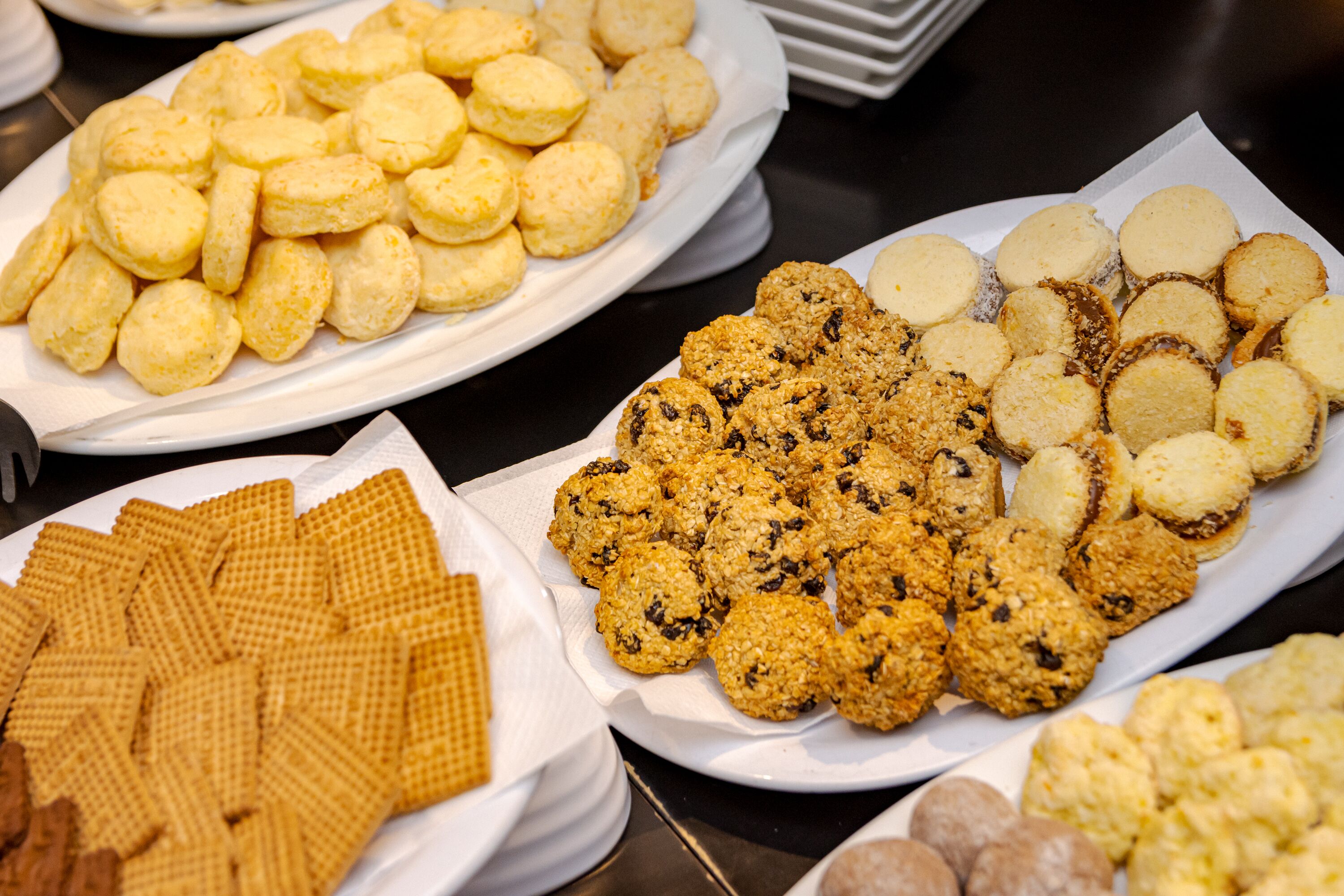 Un buffet proposant une variété de produits de boulangerie, notamment des biscuits, des gâteaux et des craquelins.