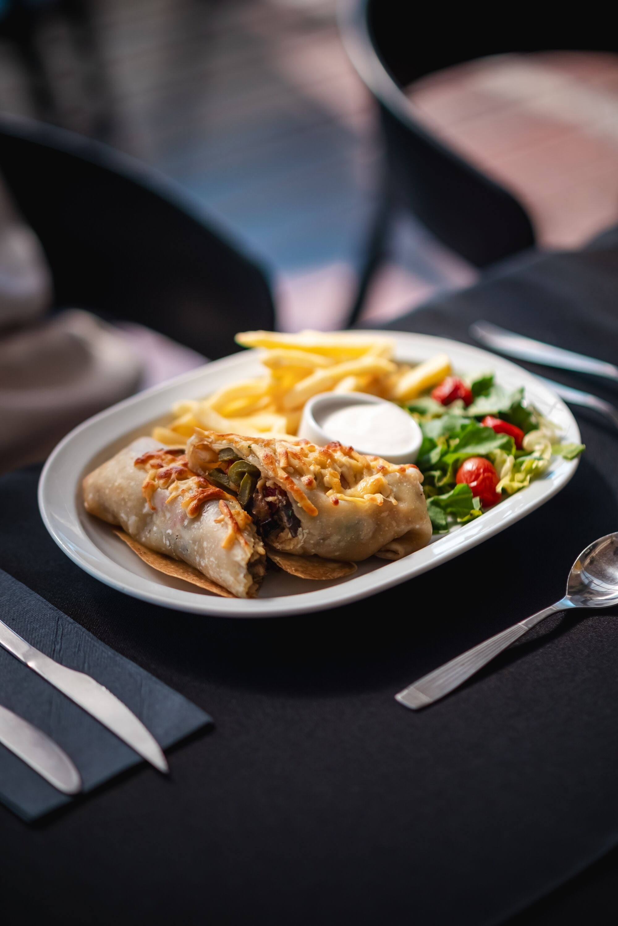 A plate of food with a salad and fries on a table.