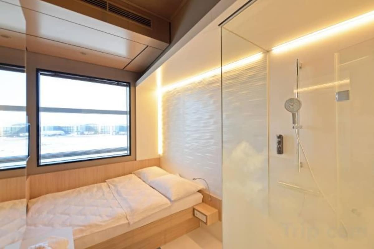 Un dormitorio con cama, ventana y zona de ducha.