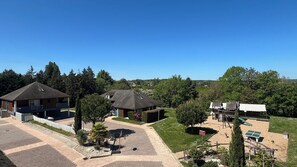 A residential area with two houses, a paved driveway, and a playground with a basketball hoop.