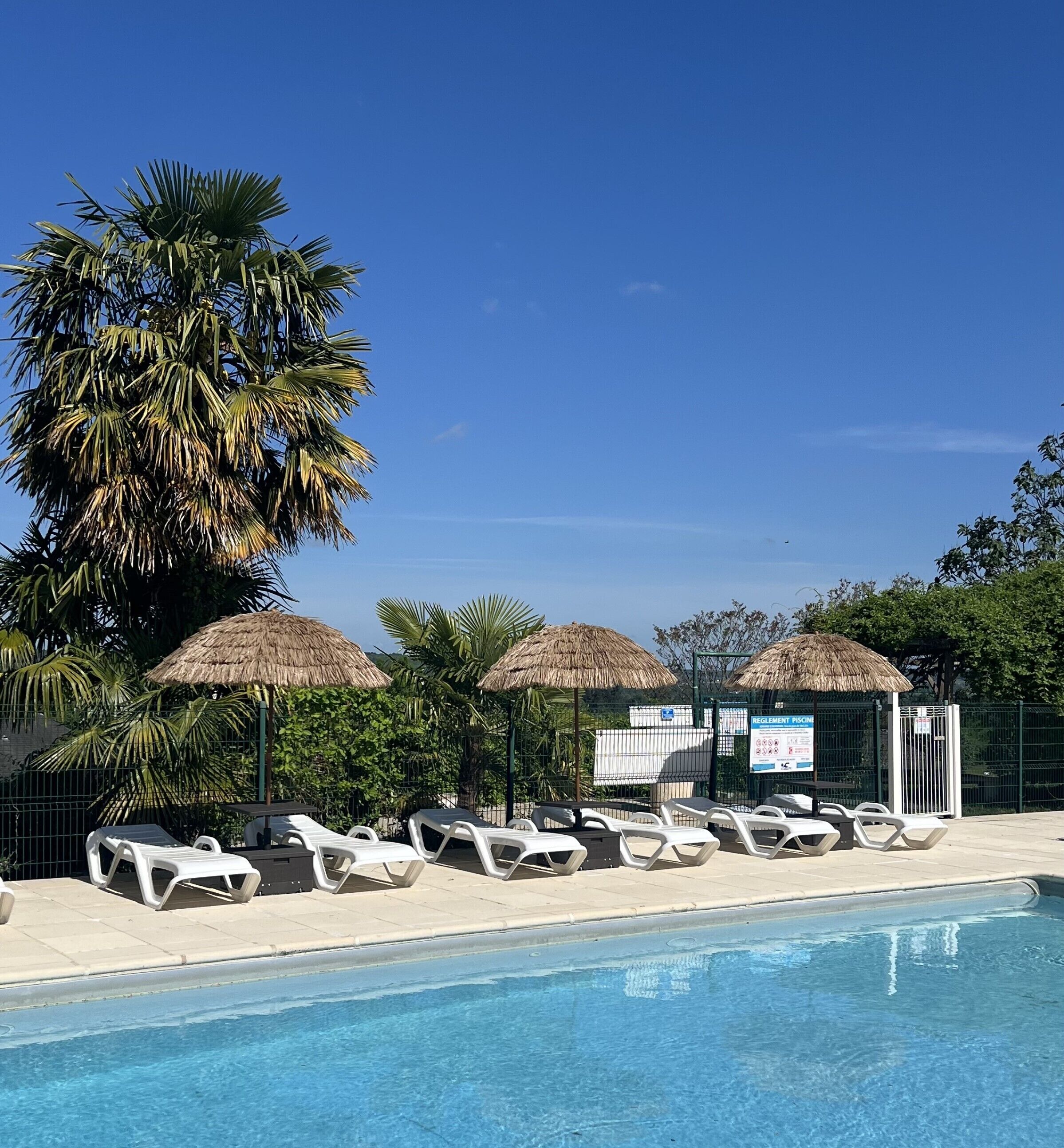 Una piscina al aire libre de temporada, sillones reclinables de piscina