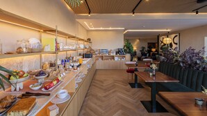 Un café moderno con mostrador de madera, zona de estar y suelo con patrón de espiga.