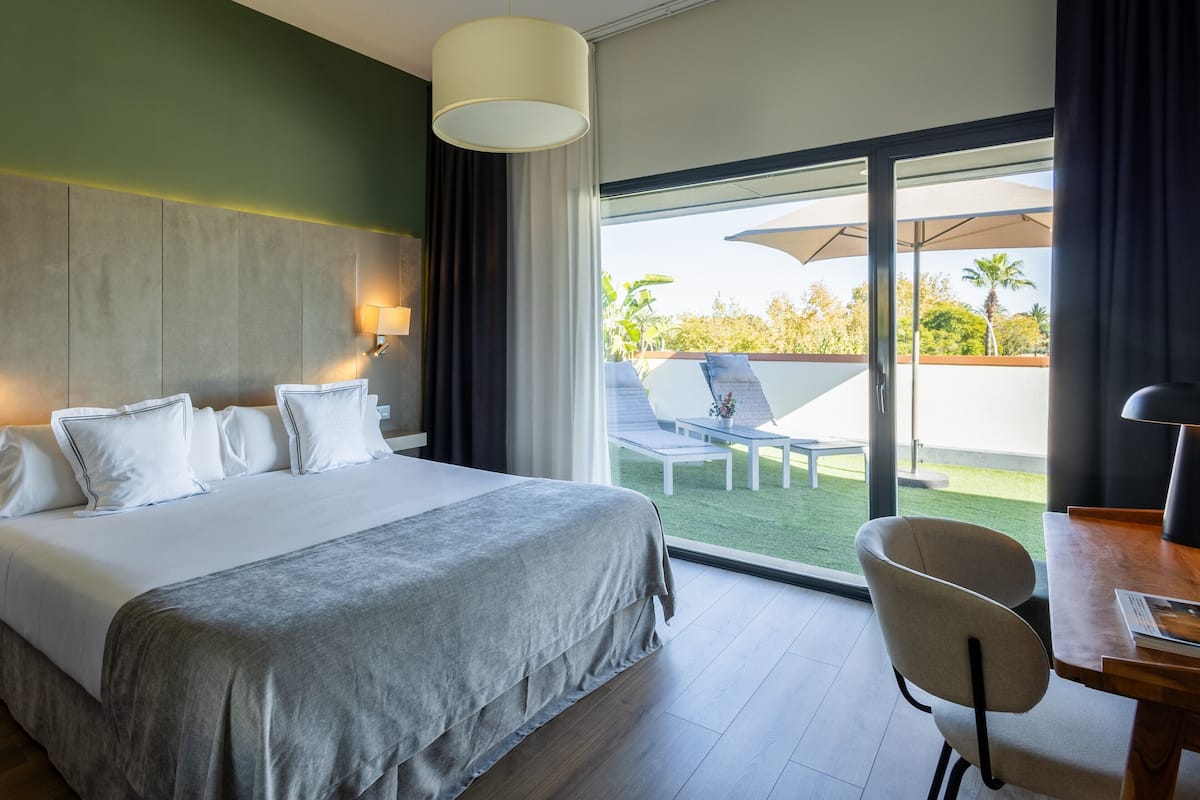 Une chambre d’hôtel avec un lit, une chaise, une table et une vue sur l’espace extérieur.