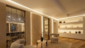 Un interior moderno con una zona de bar, asientos y estanterías decorativas.