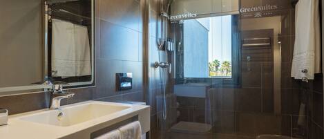 A modern bathroom with a glass-enclosed shower, a sink, and a toilet.