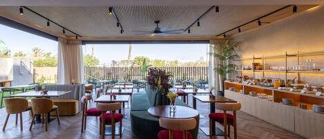 A modern restaurant with a mix of seating options, including tables and booths, and a buffet area with various food items.
