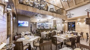 A restaurant with wooden interior, multiple dining tables, and chandeliers. - Fenomen Plitvice (Plitvicka Jezera)