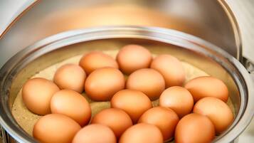 A stainless steel pot containing multiple eggs.