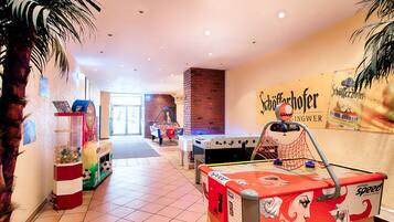 Eine Hotelhalle mit Kicker, Billardtisch und einem Automaten.