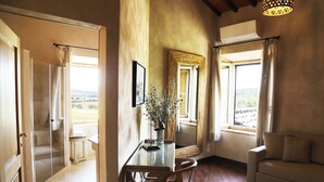 Ein Zimmer mit Glastisch, einer Couch und Blick ins Freie.