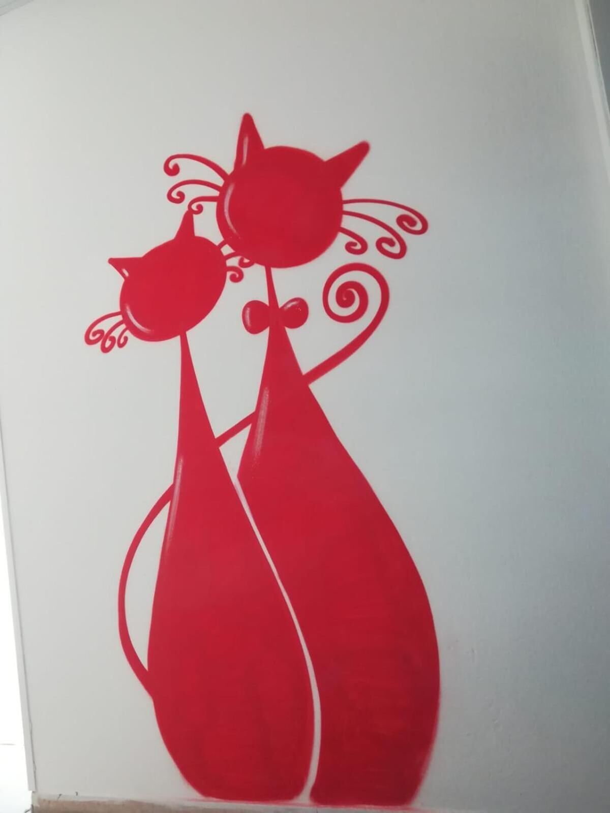 A red silhouette of a cat and a dog on a white background.